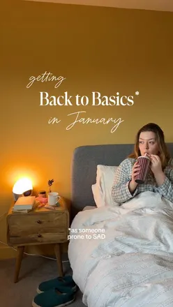 Cozy Sunday vibes with a cup of cinnamon collagen cappuccino and a book by the window, embracing January's slow pace.