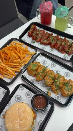 Image of a delicious spread at Delicious Kitchen in Toddington, featuring burgers, wings, and sides.