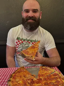 Diner enjoying margarita pizza and mozzarella sticks at Slice Syndicate, Edinburgh, with Jarritos soda.