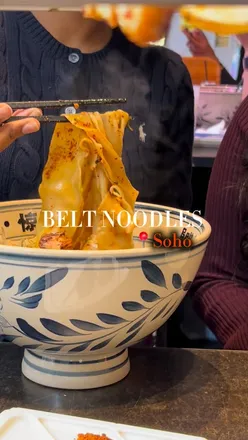 Enjoying hand-pulled noodles and grilled veggies at Belt Noodles in Soho, a top spot for hearty meals this winter.