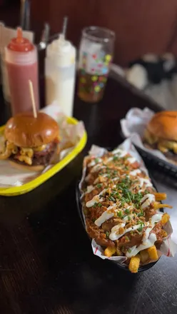 Two friends enjoying vegan burgers and fries at Rabbit Food, exploring delicious options in Edinburgh.