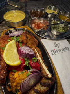 Delicious mixed platter at Jinnah Restaurants in Leeds, showcasing tasty curry in a traditional setting.