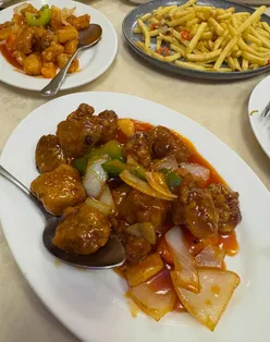 Din diners enjoying diverse dishes at Dragons Delicacy in Bristol, showcasing a vast Chinese menu.