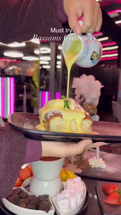 Interior of Rassam's Liverpool branch showcasing desserts served by a robot, perfect for dessert lovers.