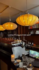 A dimly lit, atmospheric shot of a coffee machine and bar area, intended to showcase the venue's transition from a daytime cafe to an intimate evening spot.