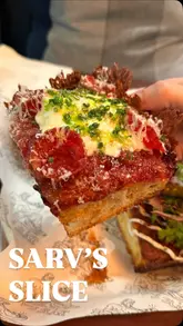 A short, punchy review of Sarv's Slice in Ealing, focusing on their Detroit-style pizza. The video features close-up shots of various pizza slices, including vegetarian and halal options, as well as garlic focaccia fingers and a dessert. It highlights the crispy crust and toppings, providing a clear look at the menu and the food quality.