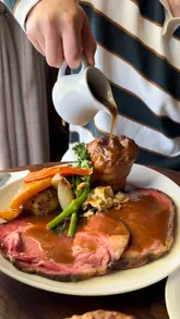 A travel vlog showcasing a stay at The Flower Pot Hotel, featuring the hotel's cosy rooms, scenic riverside location, pub garden, and dining experience including a Sunday roast.