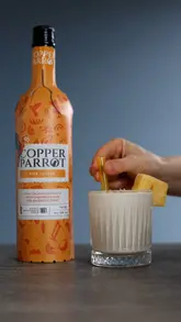 A short, instructional video demonstrating the preparation of a Piña Colada using Copper Parrot rum. The video features clean, static shots of cutting a pineapple, blending the drink, and garnishing the final cocktail.