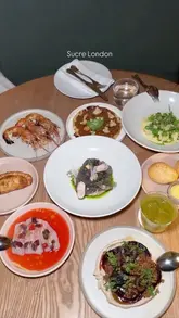 A high-quality montage showcasing the interior and a variety of dishes at Sucre London, an Argentinian restaurant. The video features close-ups of food preparation and plating, cocktails, and the elegant dining room.