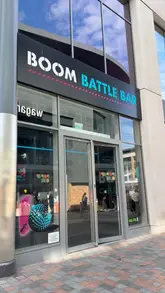 A promotional video for Boom Battle Bar, highlighting the 'Boom Bundle' offer which includes games like crazy golf, shuffleboard, axe throwing, and darts, alongside a selection of bar food and drinks.