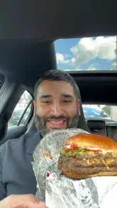 A creator provides an honest, detailed review of a meal from Wendy's, including a Dave's Triple burger, chicken nuggets, fries, and a chocolate frosty, while sitting in his car.