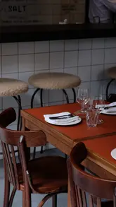A polished, cinematic montage showcasing the interior and food offerings of Holy Carrot Bistro in Spitalfields. The video features slow, aesthetic pans of the dining space, a bartender preparing cocktails, and close-ups of various vegetarian dishes, accompanied by a text overlay challenging the perception of vegetarian food.