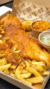 A short, punchy montage showcasing the food offerings at Fenham Fish Bar in Newcastle. The video features close-up shots of fish and chips, curry sauce being poured, the menu board, and the shop exterior, emphasizing the quality and presentation of the takeaway food.