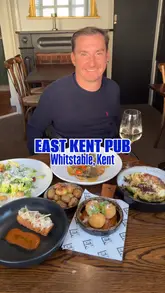 A review of the East Kent Pub in Whitstable, featuring a variety of dishes including a crispy chicken caesar salad, sea bass, arancini, crab on toast, and sticky toffee pudding. The video highlights the pub's interior and outdoor garden area.