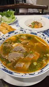A video review of Cafe East, a Vietnamese restaurant, featuring a tour of the interior, a look at the menu, and a taste test of several dishes including salt and pepper prawns, spring rolls, bun bo hue, and pho.