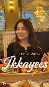 A review of The Grand by Ikkayees in Liverpool, highlighting the restaurant's aesthetic, the dramatic presentation of the seafood platter, and the unique serving of chicken curry in a coconut.