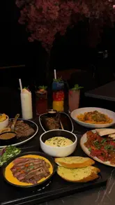 A promotional video for Grillz steakhouse in Birmingham, featuring a montage of various dishes including steaks, pasta, lamb chops, and desserts, set to music with text overlays highlighting the venue.