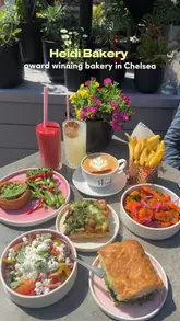 The video is a review of Heidi Bakery, located in the Royal Hospital Chelsea. It highlights the 'Lunch with Love' deal, various vegetarian food options, pastries, and the surrounding historic courtyard and museum.