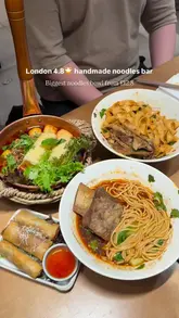 A short-form video review of a London noodle bar, featuring close-ups of various noodle dishes, beef ribs, and appetizers. The creator demonstrates the food, including eating on camera, and provides text overlays with pricing and dish details.
