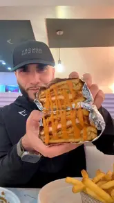 A review-style video featuring a visit to Chocstop in Nelson, showcasing a variety of indulgent food items including loaded fries, a chicken toastie, a burger, pancakes, cookie dough, waffle balls, and a matcha drink. The creator provides commentary on the food quality and experience.
