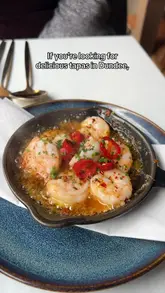 A review of The Selkie, a tapas restaurant in Dundee, showcasing various dishes including prawns, halloumi, chorizo with black pudding, and patatas bravas, alongside the cozy interior and dessert options.