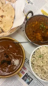 A montage-style video showcasing various Indian dishes including paneer tikka, samosas, and curries, followed by a brief clip of a 'stop the clock' discount game at the restaurant.