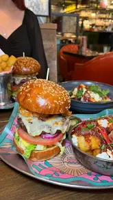 A promotional video showcasing a new potato-themed menu collaboration between Poppy Cooks and Bill's restaurant, featuring close-ups of burgers, crispy potato sides, and cocktails.