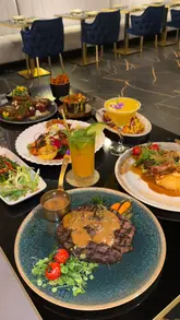 A high-quality, visually focused montage showcasing the premium steakhouse offerings and elegant interior of AVA Grill. The video features slow-motion close-ups of various dishes, including steaks, grilled prawns, and desserts, alongside shots of the restaurant's modern, spacious dining area.
