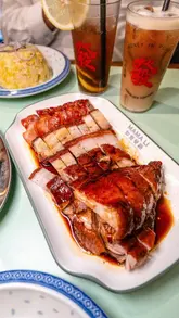A montage of various Cantonese dishes served at Mama Li, including roast duck, pork belly, char siu, beef ho fun, dumplings, French toast, and bao, presented in a casual, appetizing style.
