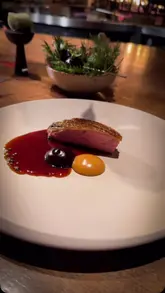 A series of cinematic, slow-motion shots showcasing an eight-course tasting menu at IGNI in Mayfair. The video highlights the intricate plating and the open-flame cooking technique used in the kitchen, set to music without any voiceover or text overlays.