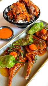 A montage of various Pan-Asian dishes served at East Lane, featuring close-ups of dumplings, lamb racks, noodles, and desserts. The video focuses on the food presentation with smooth, stable camera work.