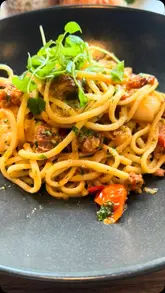A montage video showcasing the exterior, interior, and garden of The Stroud Hotel, followed by a selection of dishes including scallops, prawn and chilli linguine, halloumi fries, and a sirloin steak, accompanied by a rosé spritzer.