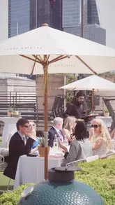 A montage showcasing a rooftop dining experience at Coq d'Argent in partnership with Mirabeau rosé. The video features shots of the venue setup, staff service, guests enjoying wine and food, and the London skyline.