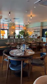 A promotional video for Coppa Club Putney, featuring shots of the restaurant's interior, outdoor riverside igloo seating, and various dishes including shrimp toast, salad, and a meat dish with couscous.