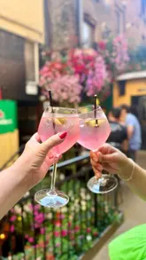 A montage of various colourful spritz cocktails served at The Hairy Lemon, featuring an outdoor seating area.
