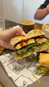 A short, punchy reel showcasing brunch items including Turkish eggs and a bagel, along with coffee and matcha drinks at a cafe. The video features close-up shots of the food and a brief exterior shot of the venue.