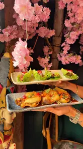 A couple visits a Thai restaurant called Khao San Road, showcasing a variety of dishes including noodles, lettuce wraps, and beef floss, while highlighting the authentic ingredients and sharing-style menu.