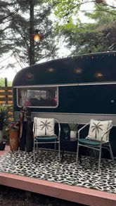 A short, atmospheric video showcasing a private cinema setup inside a glamping Airstream trailer, featuring a projector screen, cozy bedding, and movie snacks.