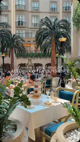 A high-quality promotional video showcasing the Palmaráe x Winter Garden Afternoon Tea at The Landmark London. The video features slow, cinematic pans of the hotel's iconic glass-roofed atrium, close-ups of the afternoon tea spread including pastries, finger sandwiches, and scones, and shots of tea being poured and cocktails being toasted.