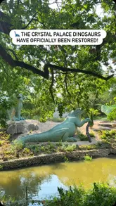 A video showcasing the restored dinosaur statues at Crystal Palace Park, featuring slow, steady shots of the various sculptures in their park setting, accompanied by text overlays announcing the restoration and upcoming event details.