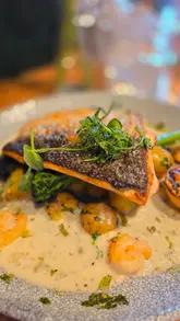 A promotional montage showcasing the newly refurbished Spread Eagle pub, featuring shots of the interior, outdoor seating area, and various menu items including a Sunday roast, fish and chips, and a burger.