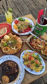 A fast-paced montage showcasing a variety of Filipino dishes and drinks at a restaurant, featuring close-ups of food being dipped, pulled, and served on an outdoor terrace.