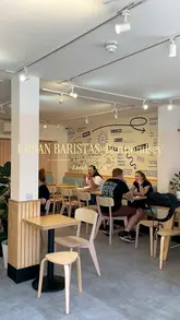 A short, straightforward tour of the Urban Baristas cafe in Bermondsey, London, showcasing the exterior, interior seating, counter, and menu, concluding with a shot of an iced coffee.