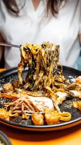 A montage of high-quality food shots at Hoax London, featuring dishes like beef and bone marrow tartare, carbonara, red prawn tagliatelle, and a chocolate dessert, followed by a brief glimpse of the interior and a toast.