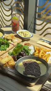 A creator visits Estabulo to review their new 'Café de Brazil' menu, showcasing the steak and chicken dishes with the special sauce, alongside drinks and sides in a casual dining setting.