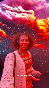 A selfie taken inside the 'TIMEWALK' immersive exhibition at Immerse LDN, featuring a vibrant, colourful digital projection background.