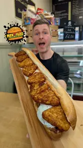 A food challenge video featuring a creator attempting to finish a massive breakfast baguette at The Village Bakery and Cafe. The video documents the challenge, the scale of the food, and the atmosphere of the cafe.