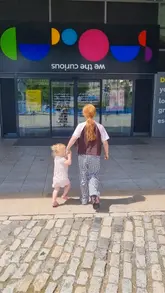 A montage of various interactive exhibits at We The Curious science museum in Bristol, featuring a child and adult exploring activities like bubble making, robotics, and music.