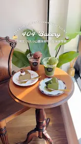 A short, aesthetic montage showcasing matcha and hojicha cheesecakes alongside matcha and chocolate floats at 404 Bakery. The video features slow, stable shots of the food on a table and a brief glimpse of the shop interior.