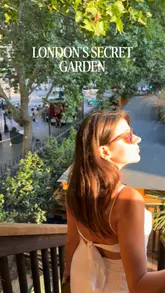 A short, handheld video showcasing a London outdoor garden venue featuring live music and a social atmosphere. The creator walks through the space, highlighting the crowd and the setting.